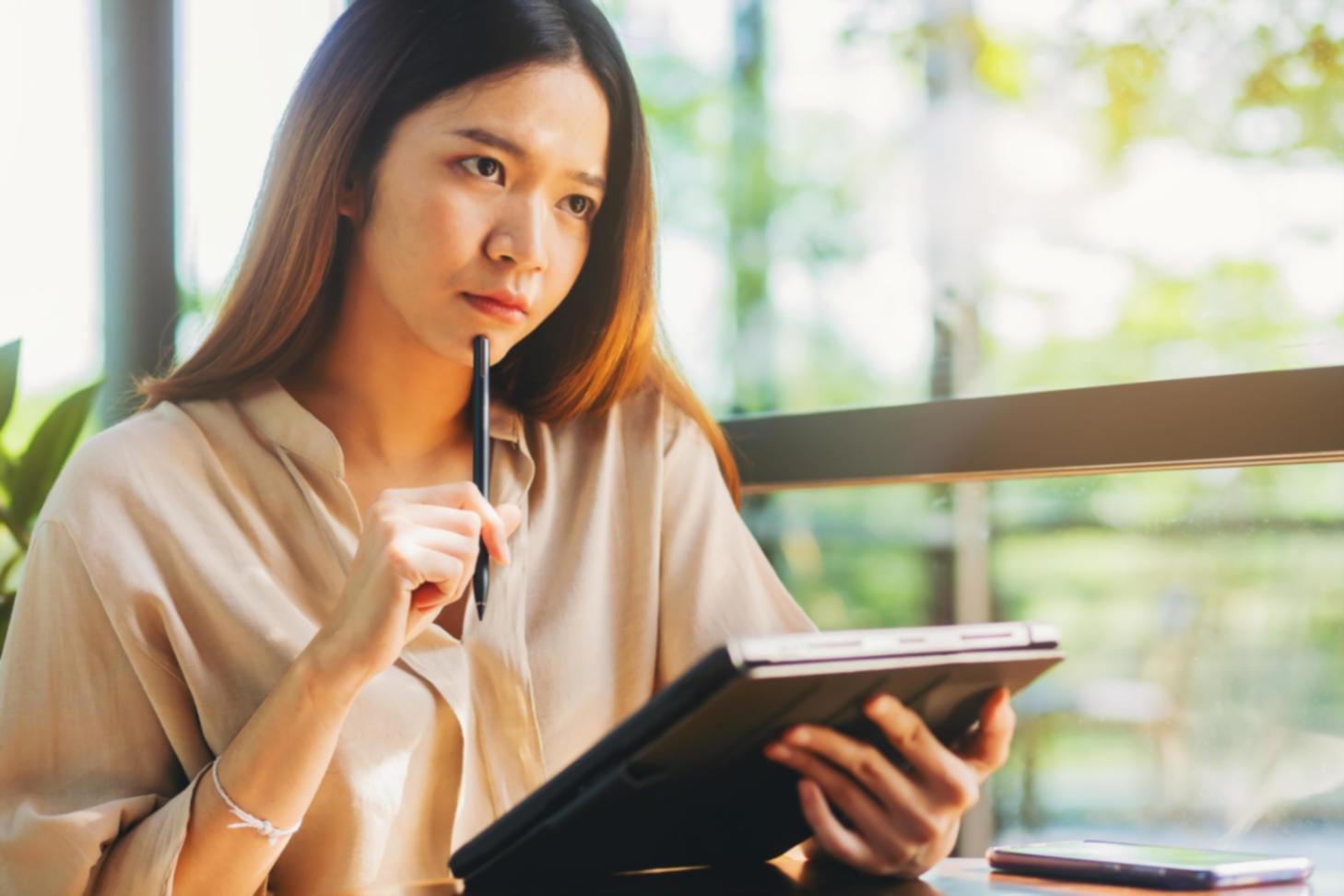 Person setting up digital financial tracking system on tablet and smartphone