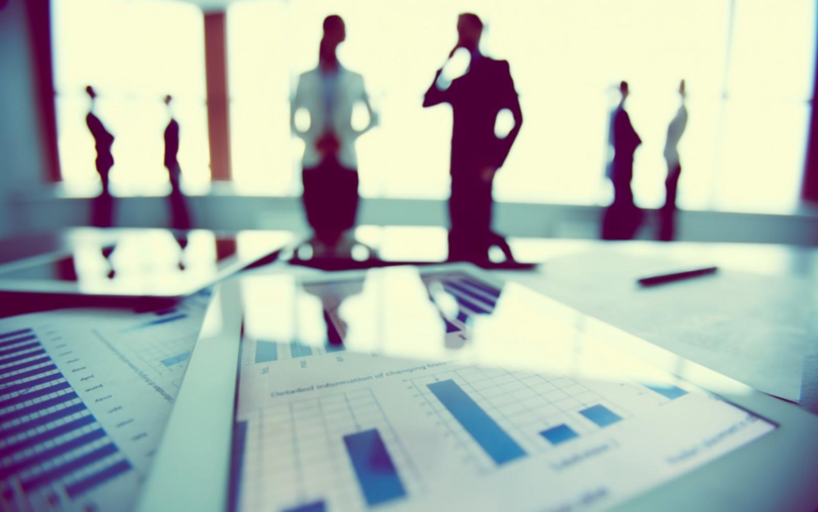 Financial workshop session with participants reviewing budget planning worksheets